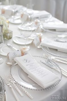 the table is set with silverware and place settings