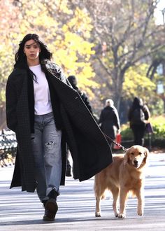 a woman walking her dog down the street