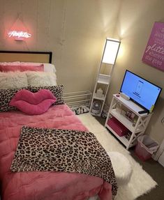 a bed room with a neatly made bed and a flat screen tv on the wall