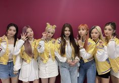 the girls are posing together in front of a pink wall wearing yellow and white outfits