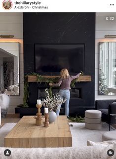 a woman is standing in the living room with her arms out and looking at the television