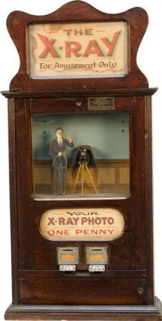 the x - ray toy is on display in an old wooden case with a man standing next to it