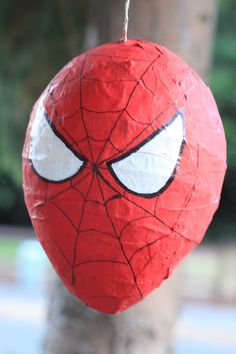 a spiderman paper ball hanging from a tree