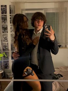 a man in a suit taking a selfie with a woman