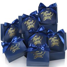 six blue gift boxes with gold lettering on them are wrapped in satin ribbon and have the words thank you