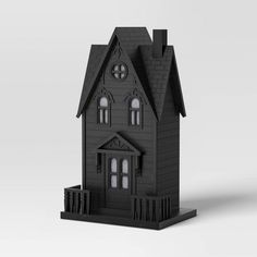 a black model of a house with two windows and a clock on the top of it