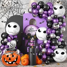 halloween decorations and balloons are arranged in front of a purple backdrop with black and white pumpkins