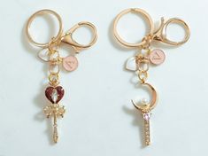 two pairs of key chains with charms attached to them, one has a heart and the other has a cross