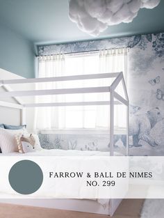 a white bed sitting under a window next to a wallpaper covered in animals and clouds