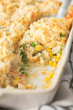 a casserole dish filled with chicken and veggies on a table cloth