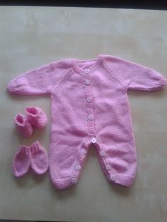 a baby's pink knitted outfit and booties are laying on the floor