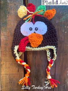 a crocheted penguin hat hanging on the side of a wooden fence with text overlay that says, ` silly turkey hat '