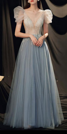 Discover this dreamy dusty blue evening gown, perfect for weddings, galas, and special occasions. Featuring a beaded bodice, V-neckline, and romantic puff sleeves, this tulle dress embodies elegance and sophistication. Ideal for those searching for a formal whimsical fairytale fairycore enchanted fairy fantasy gown, evening dress, or wedding guest outfit. Floor-length Ball Gown With Sheer Bodice For Banquet, Tulle Evening Dress With Fitted Bodice For Banquet, Banquet Evening Dress With Fitted Bodice And Tulle, Banquet Evening Dress With Fitted Bodice, Sheer Bodice Dress For Prom Season Banquet, Ethereal Evening Dress With Fitted Bodice For Party, Tulle Evening Dress For Prom Season Banquet, Tulle Evening Dress For Prom Banquet, Sheer Bodice Floor-length Gown For Banquet