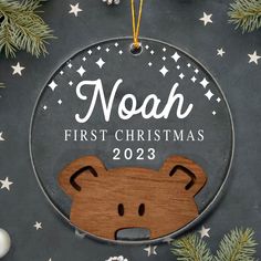 a wooden ornament with a bear on it and the words noah first christmas