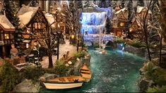 a boat is in the water next to a christmas village