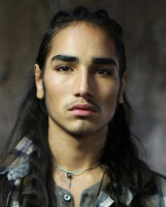 a young man with long hair and a moustache