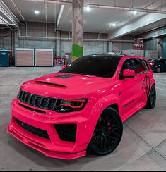 a bright pink jeep parked in a garage