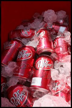 several cans of dr pepper sit in ice