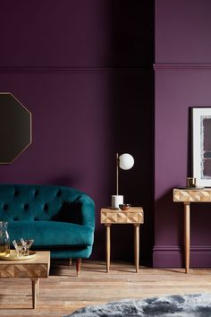 a living room with purple walls and two tables in front of the couch, coffee table