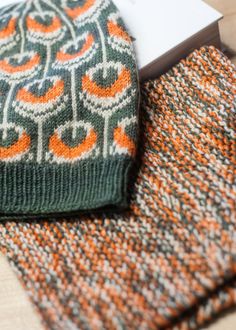 an orange and green knitted tie next to a book