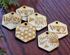 wooden honey tags with the words organic honey printed on them, sitting on a table