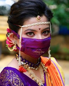 a woman wearing a purple mask and jewelry