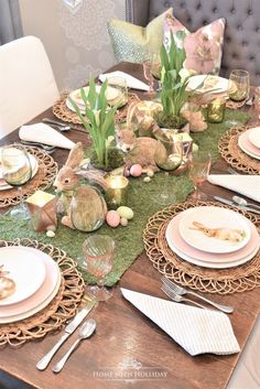 the table is set for easter dinner with pink and green decorations on top of it