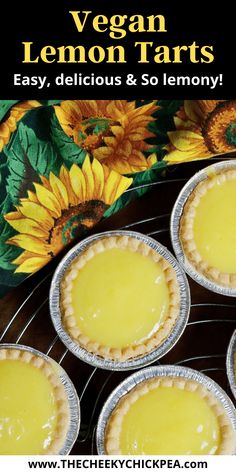 four pies sitting on top of a metal rack next to a flowery cloth