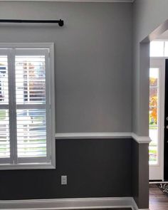 an empty room with gray walls and white shutters