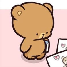 a brown teddy bear sitting on top of a pink floor next to two cards with hearts