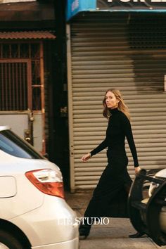 a woman walking down the street in front of a store