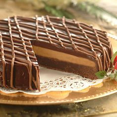 a chocolate cake on a plate with a slice cut out and strawberries in the background