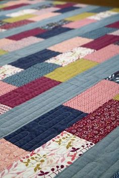 a quilted table topper with many different colors and patterns on the fabric,