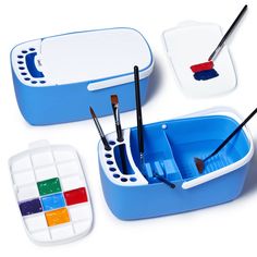 three plastic containers with paint brushes and paints in them on a white surface next to one another