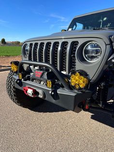 the front end of a gray jeep with yellow flowers on it's grilles