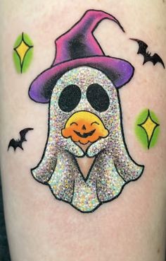 a tattoo with a penguin wearing a witches hat