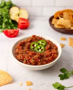 a white bowl filled with salsa next to tortilla chips