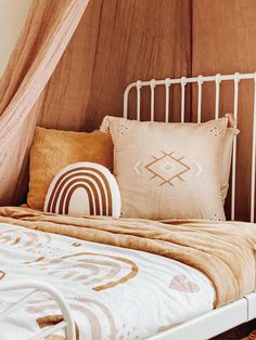 a bed with two pillows on top of it next to a curtained wall and window