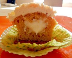 a half eaten cupcake sitting on top of a paper plate