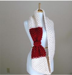 a white and red knitted scarf on a mannequin