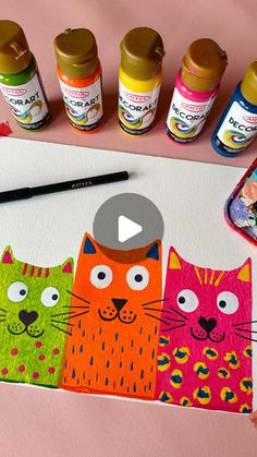 an art project with paint and markers on the table next to it is a video about how to draw cats