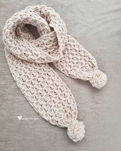 a crocheted scarf laying on top of a bed