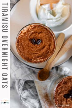 two mugs filled with hot chocolate on top of a white plate next to spoons