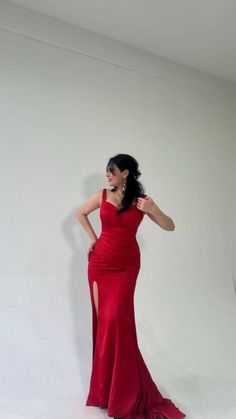 a woman in a red dress posing for the camera with her hands on her hips