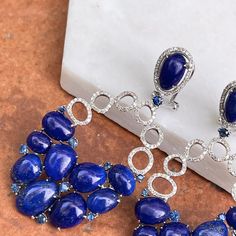 Estate/ vintage 14KT white gold oval blue lapis earrings with small round blue sapphires in-between and pave diamond accents. Stunning, show-stopping earrings! Vibrant color and sparkle to these earrings. Measures: 27mm x 55mm Weighs 14.69 grams .45 carat total weight diamonds Omega back closure Excellent estate condition Oval Sapphire Earrings With 17 Jewels, Elegant Sapphire Multi-stone Earrings, Blue Oval Earrings For Evening, Sapphire Multi-stone Earrings Fine Jewelry, Luxury Oval Sapphire Earrings, Blue Luxury Earrings With Gemstone Accents, Blue Oval Earrings With Diamond Accents, Oval Blue Diamond Earrings, Luxury Oval Lapis Lazuli Jewelry