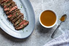 steak on a plate next to a cup of soup