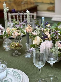 the table is set with wine glasses and flowers