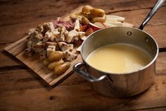 a wooden table topped with food and a cup of soup