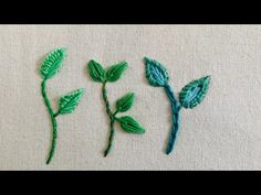 three different types of green leaves on a piece of cloth with stitching in the middle