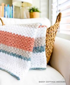 a crocheted blanket sitting on top of a white couch